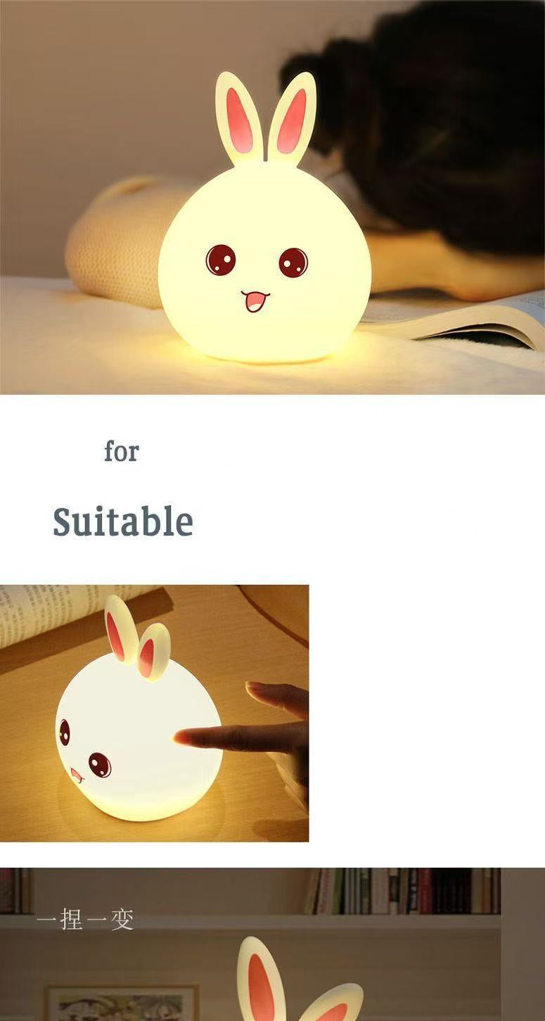 Cute rabbit-shaped night light with a soft glow on a wooden surface.