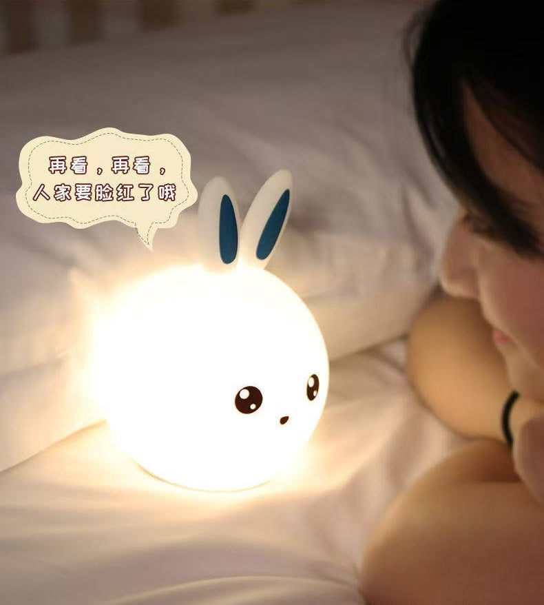 Person lying on a bed with a cartoon rabbit night light and text overlay.